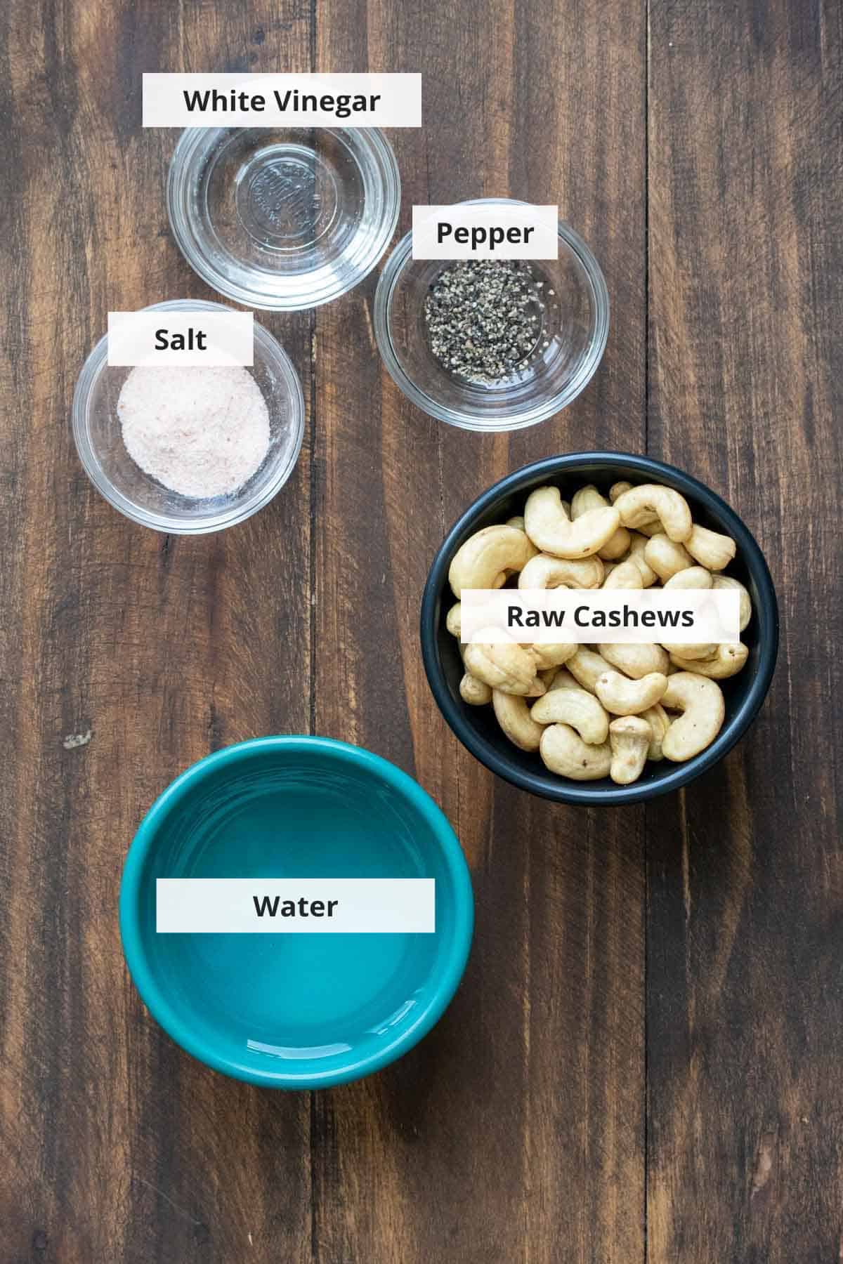 Ingredients for vegan cashew ricotta recipe on a wood background.