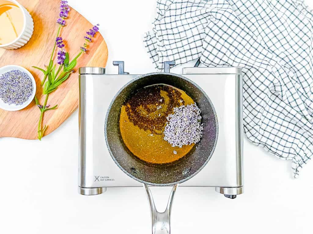 Ingredients for honey lavender simple syrup mixed in a pot on the stove.