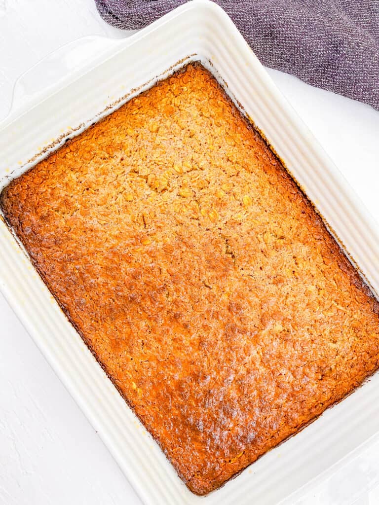 Banana peanut butter baked oats fresh out the oven, in a white baking dish.