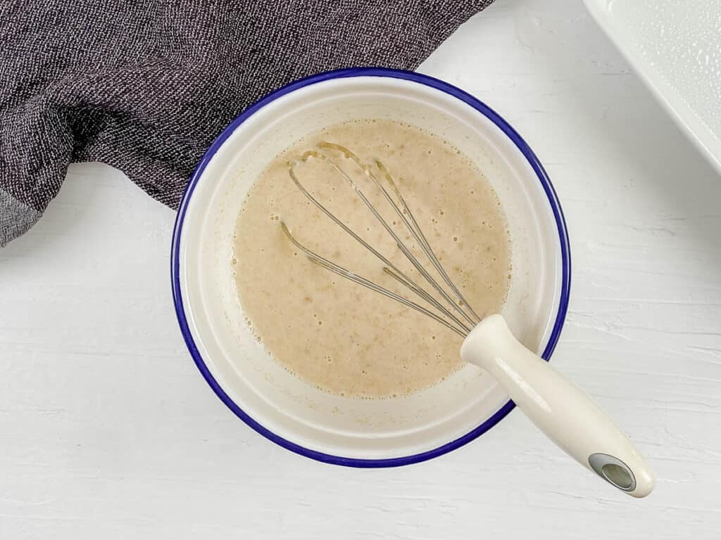 Wet ingredients for baked oatmeal mixed in a mixing bowl.