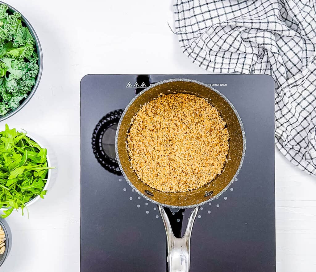 Cooked quinoa in a ، on the stove.