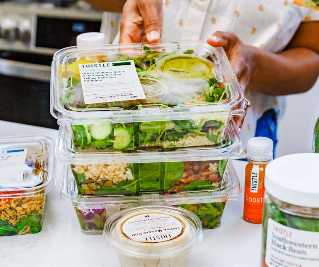 Stack of Thistle meals on a white countertop.