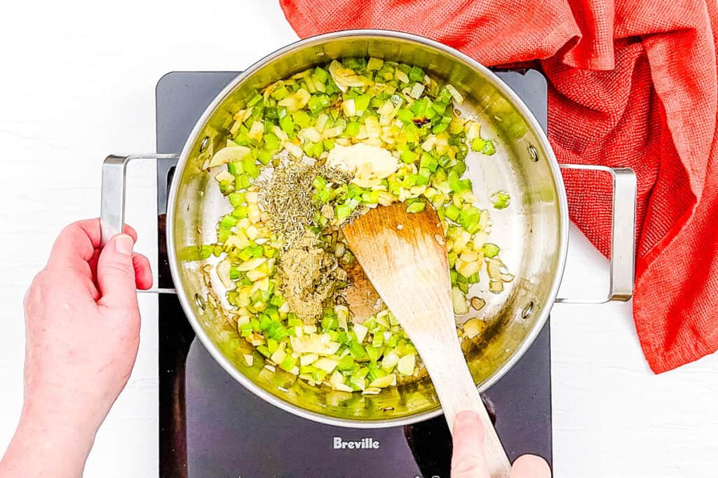 Veggies sauteeing in a pan on the stove.