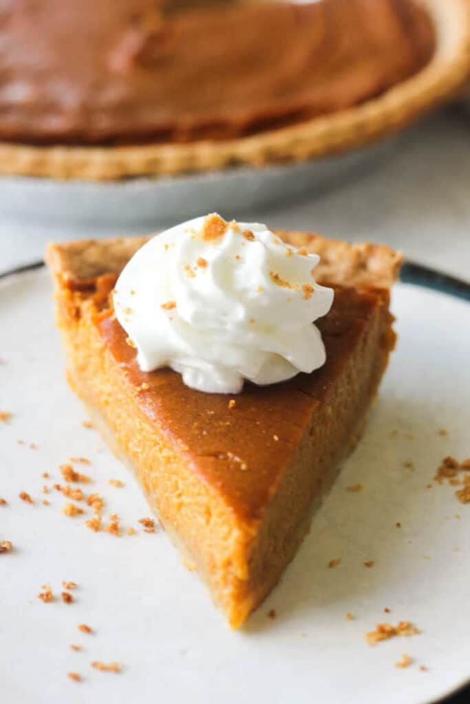 Slice of silken tofu pumpkin pie on a white plate.