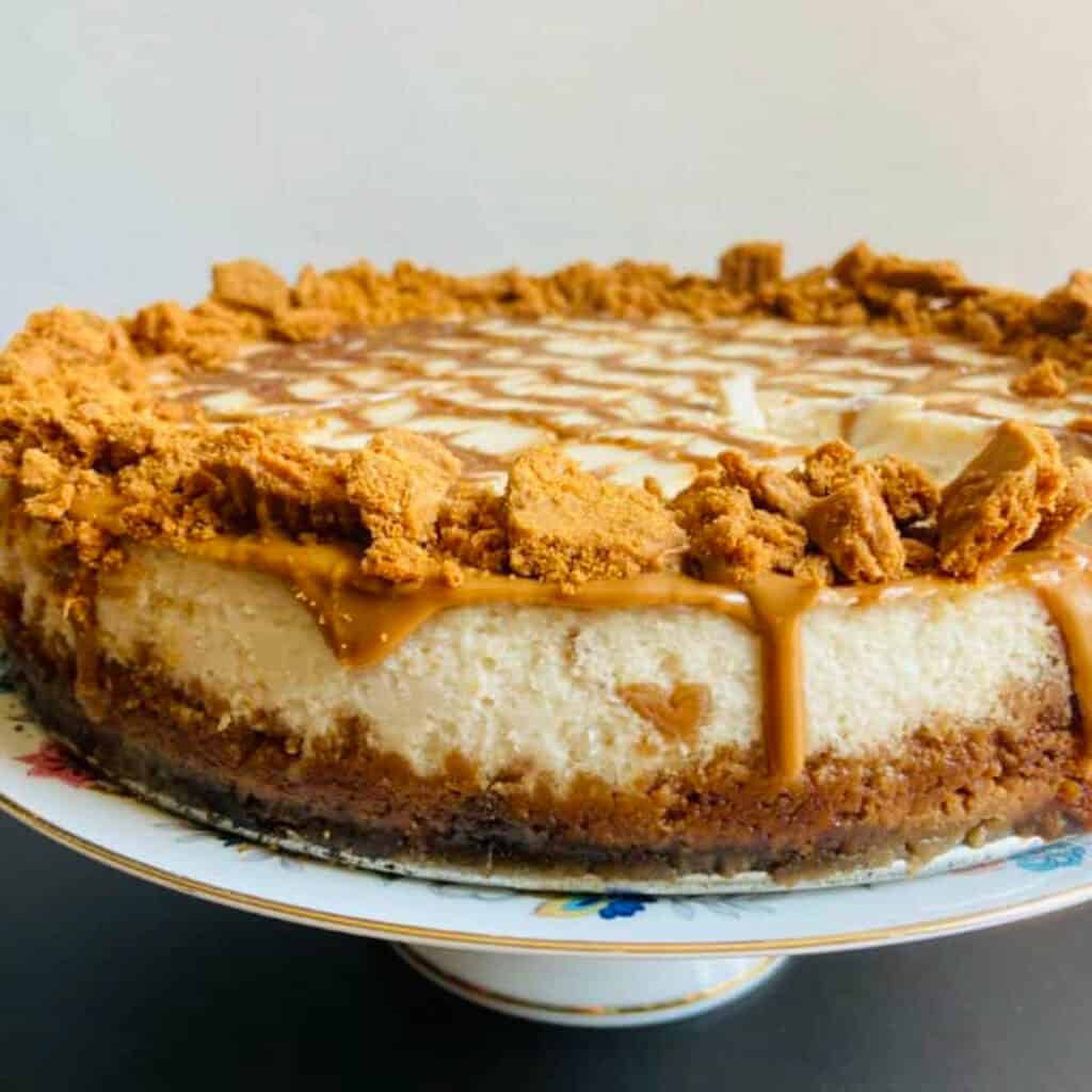 Vegan biscoff cheesecake on a cake stand.