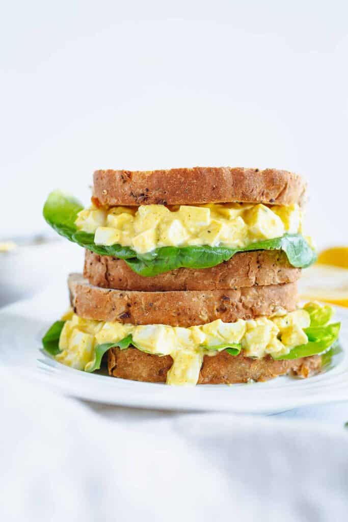 Vegan egg sandwich loaded into a sandwich with thick bread and lettuce.