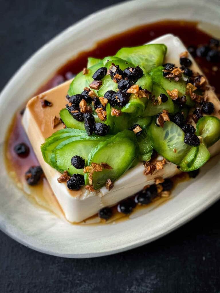 Silken tofu with fried garlic in a white serving dish.