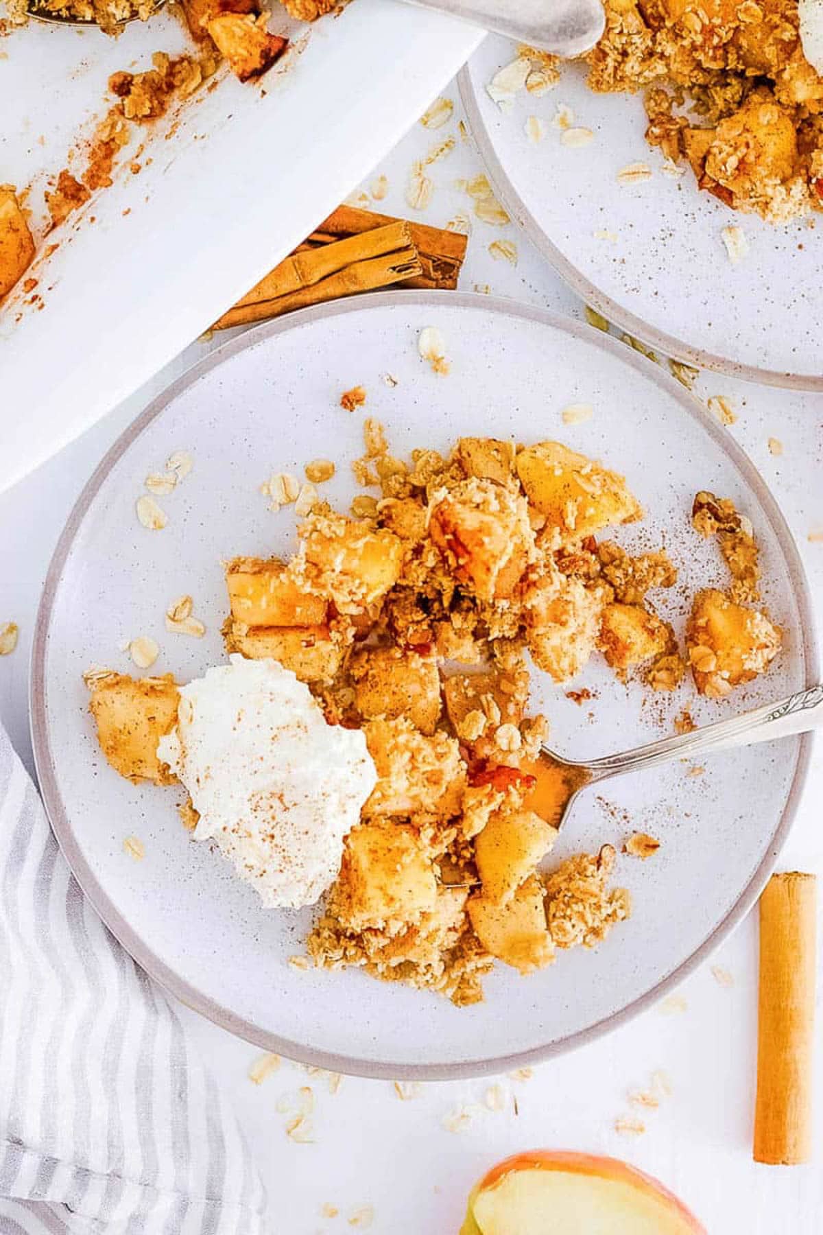 Overhead s،t of a plate of vegan apple crisp with a scoop of ice cream.