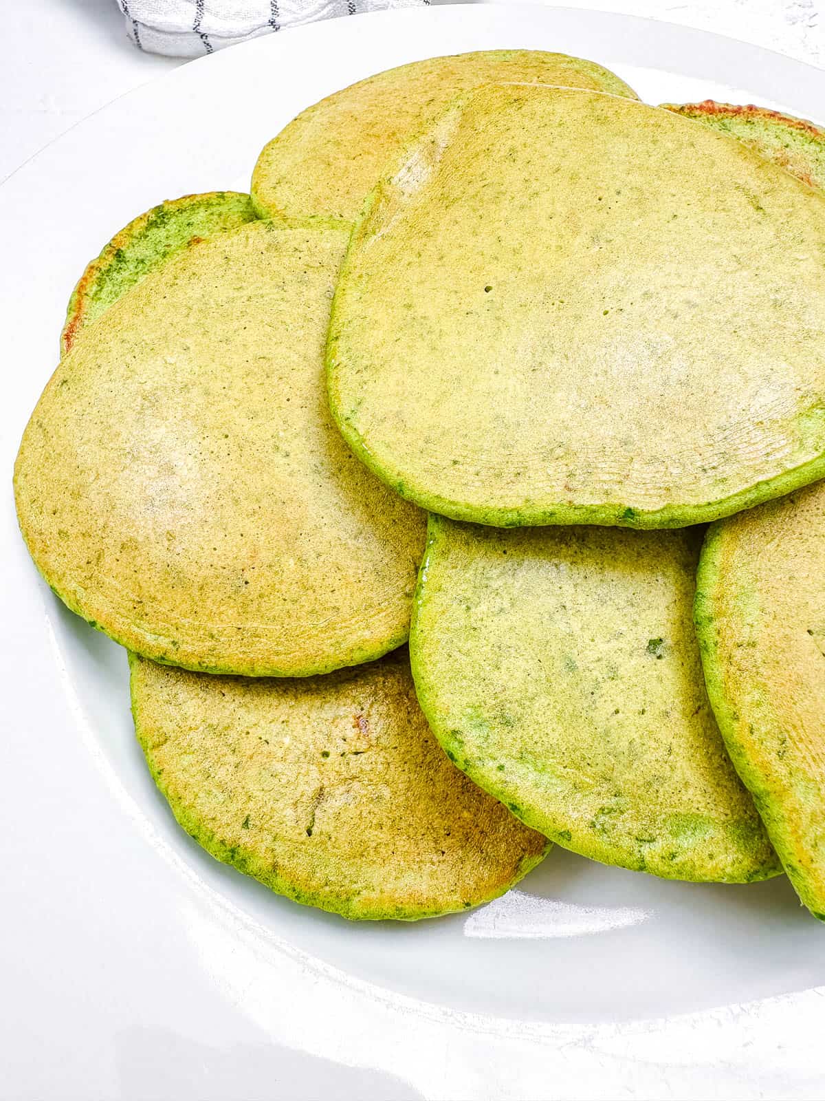 Hulk pancakes stacked on a white plate.