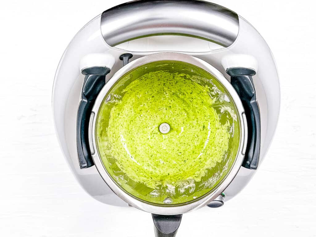 Spinach and other pancake ingredients blended in a blender.