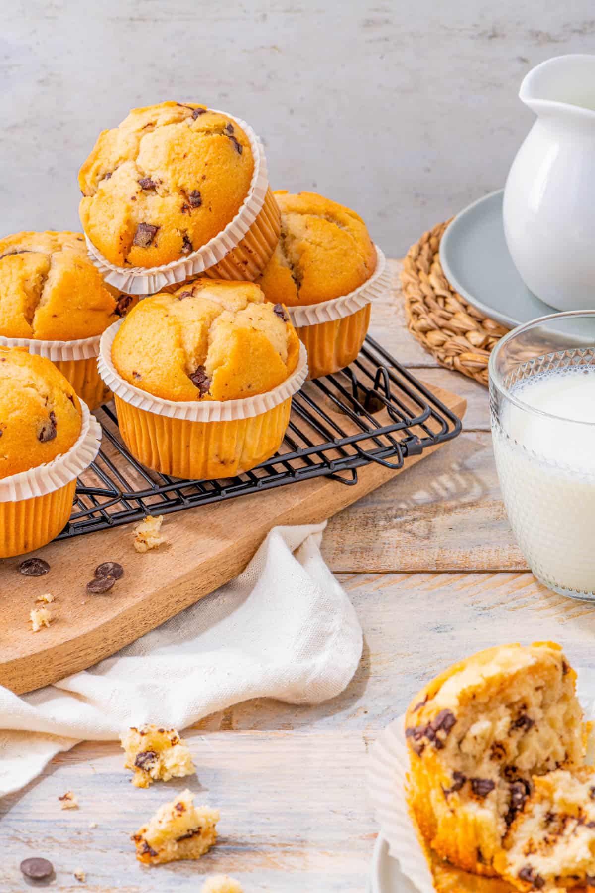 Gluten free banana chocolate chip muffins on a wire rack on a wooden cutting board.