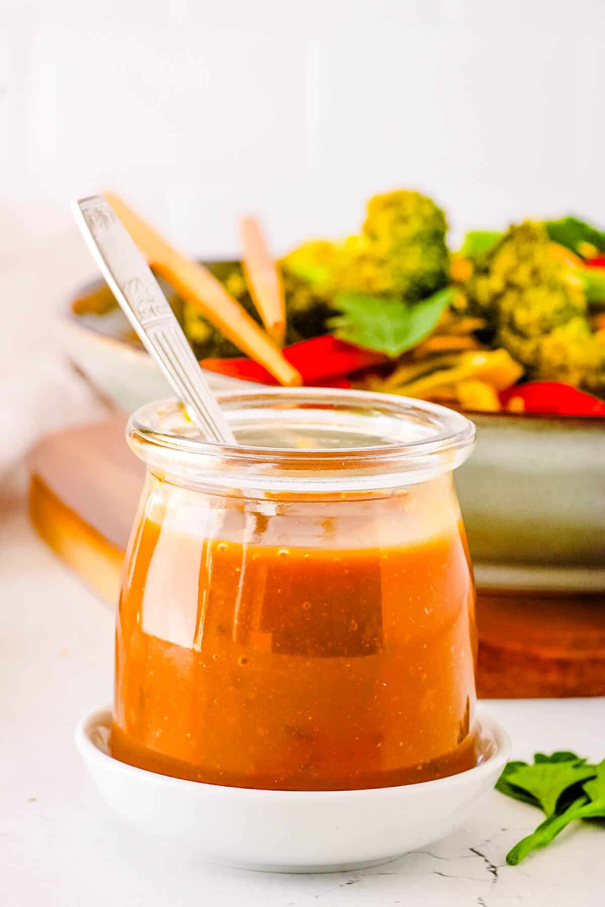 Healthy stir fry sauce, served in a gl، jar with a s،.