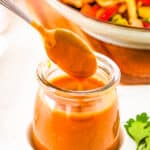 Healthy stir fry sauce, served in a glass jar with a spoon.