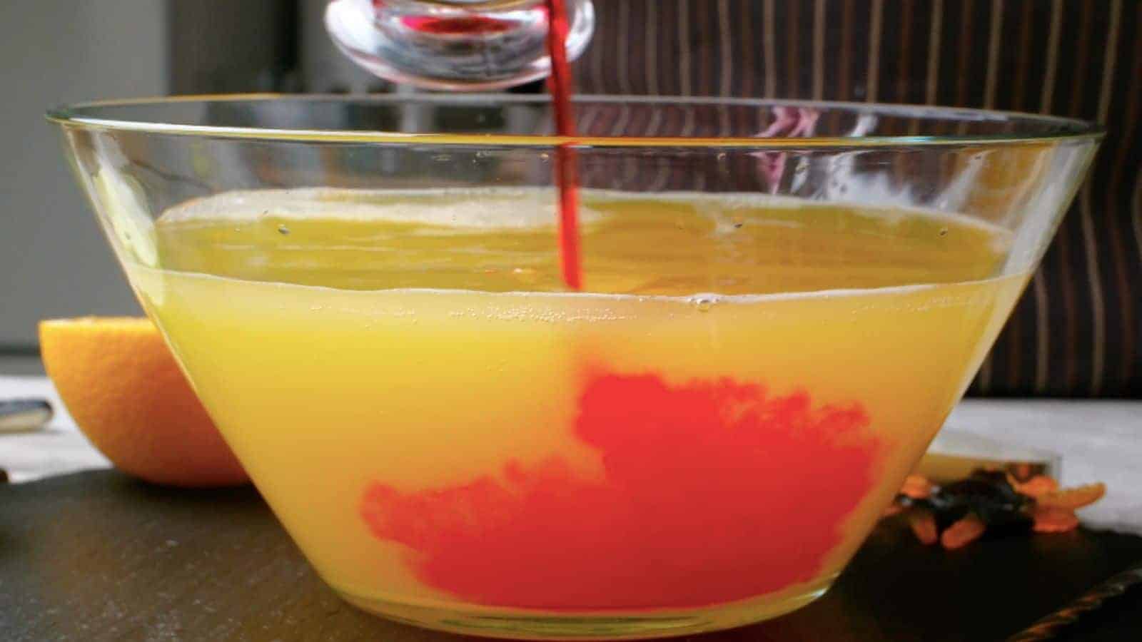 Adding grenadine to punch bowl.