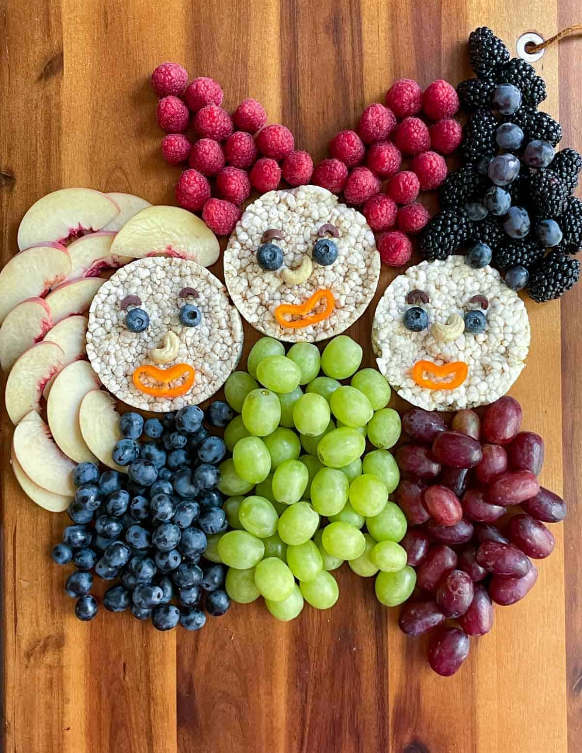 Hocus Pocus snack board with rice cake faces, fruit hair, and fruit bodies.