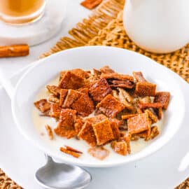 Healthy homemade cinnamon toast crunch cereal, served in a bowl with milk.