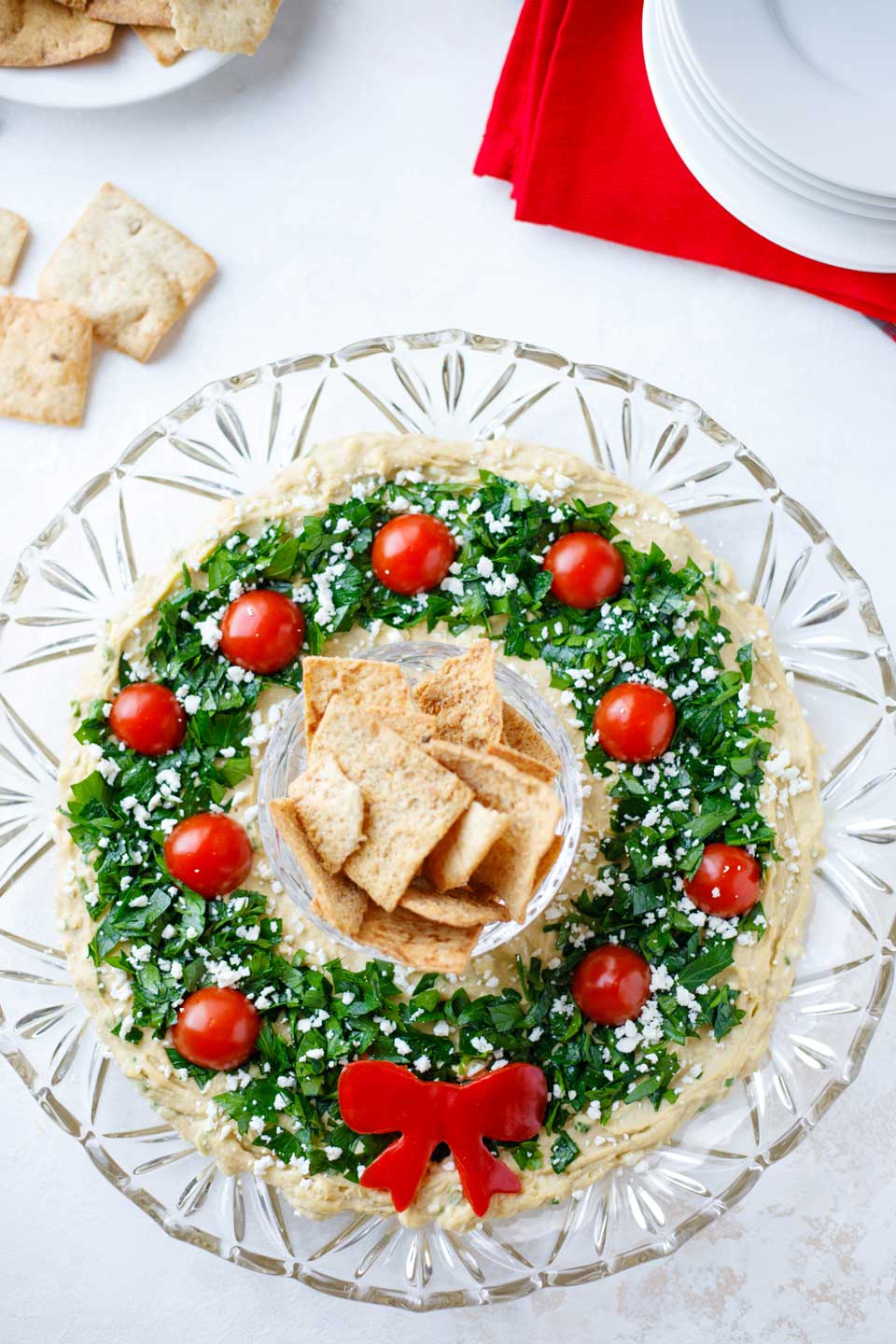 Hummus Christmas wreath appetizer on a glass plate.