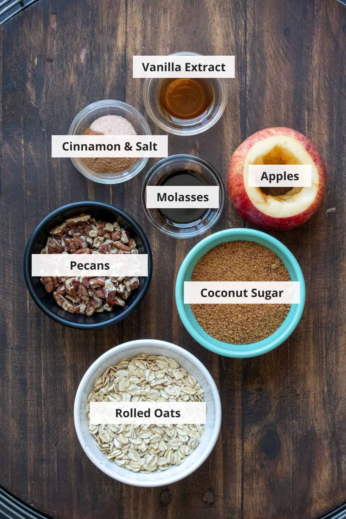 Ingredients for healthy baked cinnamon apples on a wood background.