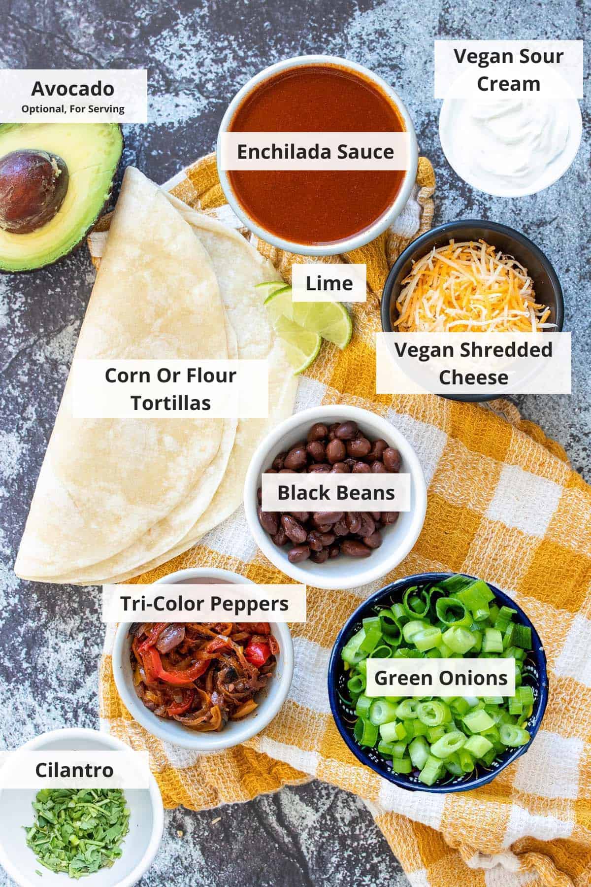 Ingredients for vegan black bean enchiladas on a grey countertop.