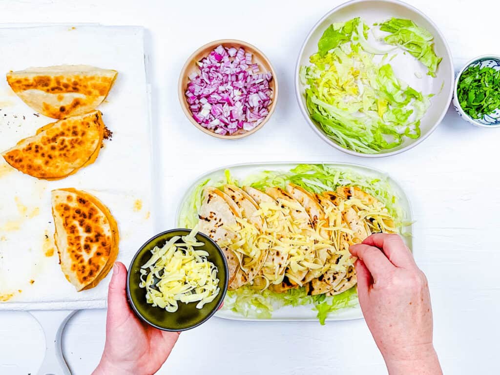 Easy crispy potato tacos (or a tacos de papa recipe) served on a white serving plate, topped with onions and cilantro.