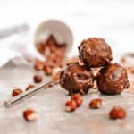 Homemade Vegan Ferrero Rocher truffles stacked on a grey cutting board.