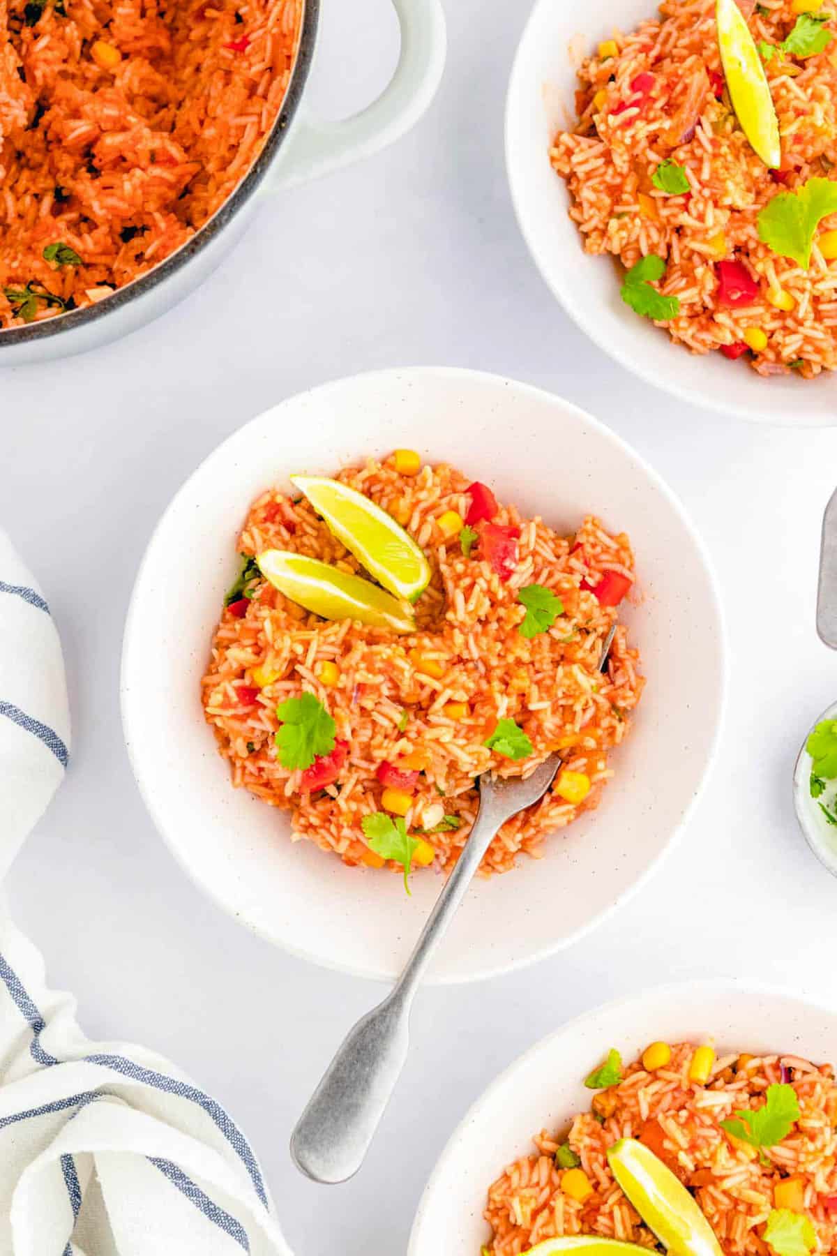 Vegan Mexican rice served in a white bowl, garnished with lime.