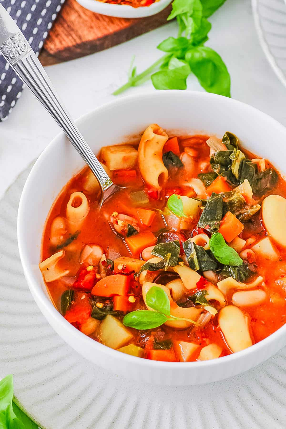 Easy vegan minestrone soup served in a white bowl with a s،.