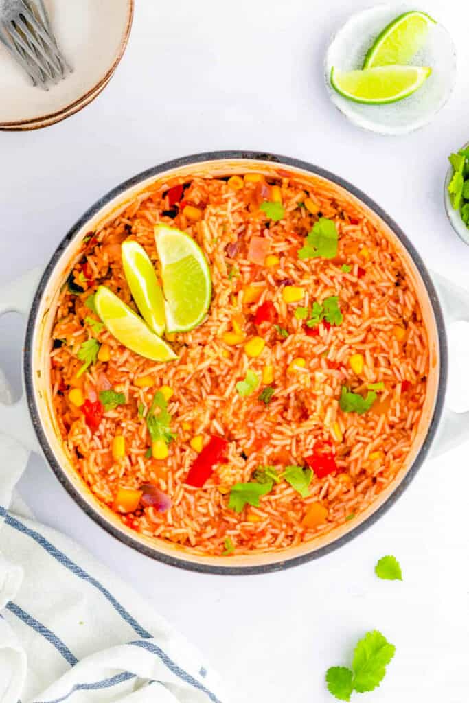 Easy vegan Mexican rice recipe in a stock pot, garnished with lime.