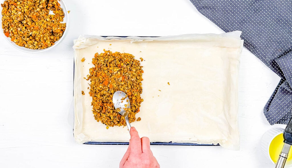 Lentil filling added to phyllo dough on a baking sheet.