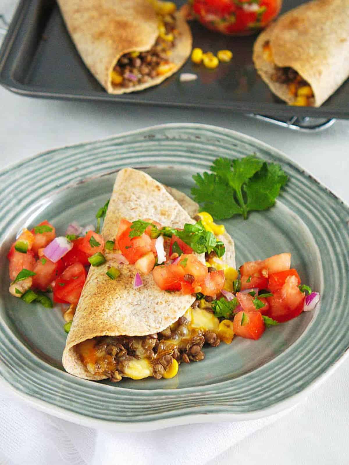 Closeup side shot of vegetarian quesadillas covered in pico de gallo.