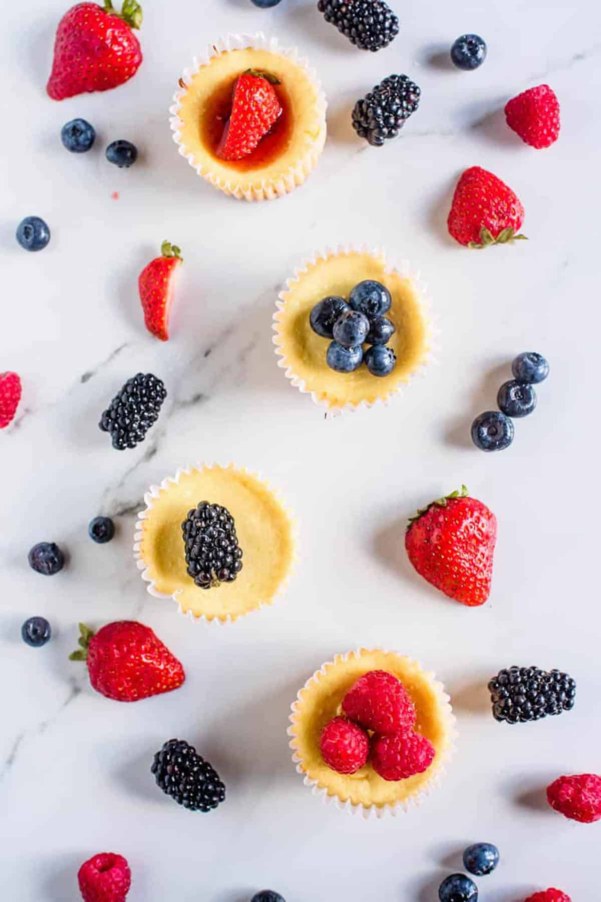 Mini cheesecake bites arranged on a white countertop.