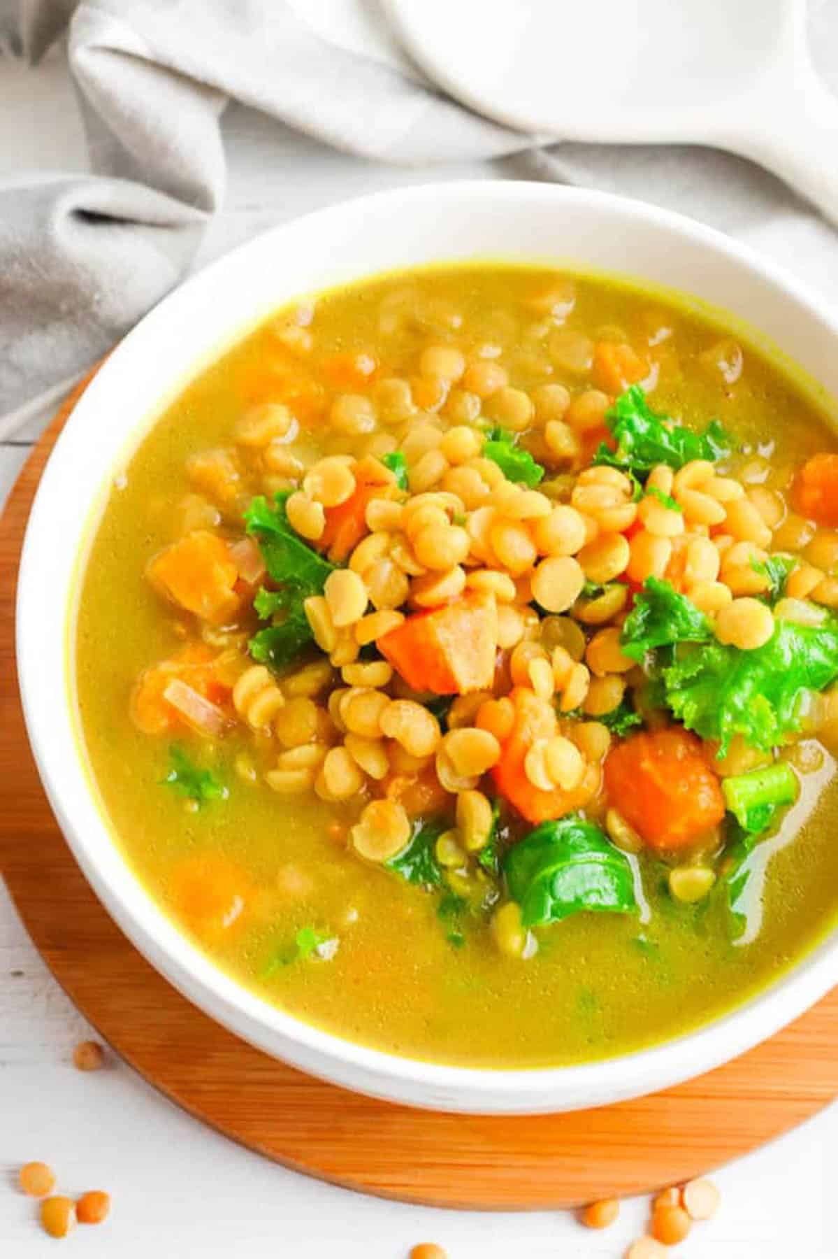 An overhead shot of a white bowl of sweet potato dal with kale.