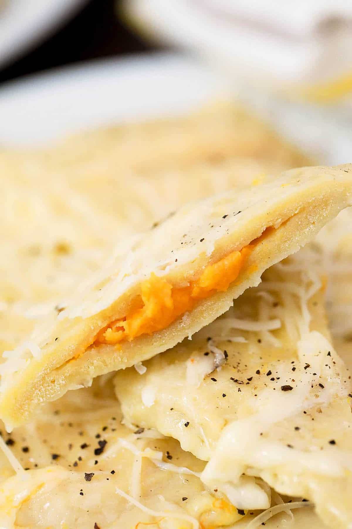 Closeup shot of a trader joe's butternut squash ravioli with the filling peeking out.