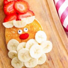 Overhead shot of Santa pancakes on a wooden cutting board.