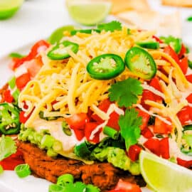 Healthy 7 layer taco dip served on a white plate.