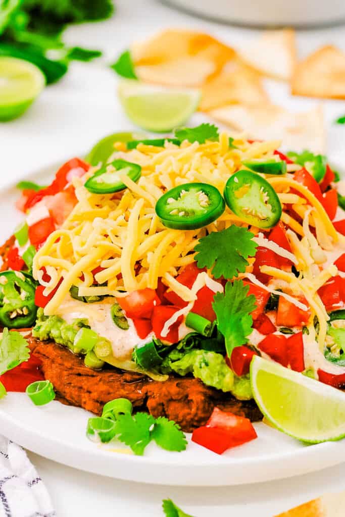 Healthy 7 layer taco dip served on a white plate.