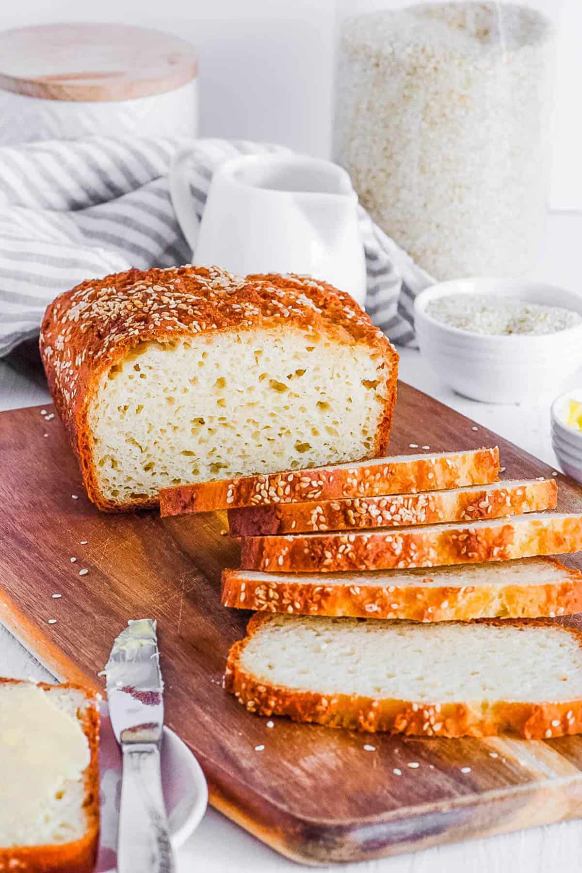 Homemade gluten free bread, sliced and served on a wooden cutting board.