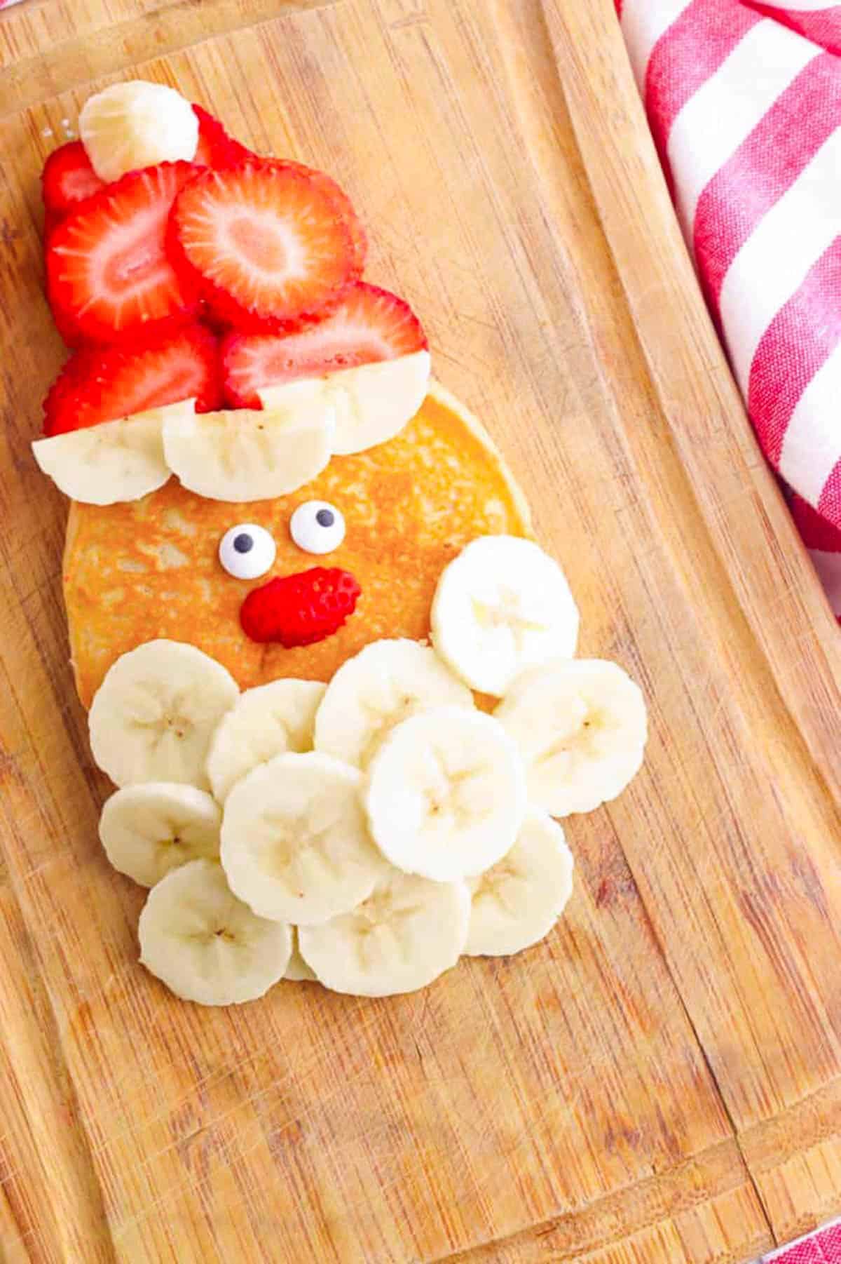 Overhead shot of Santa pancakes on a wooden cutting board.