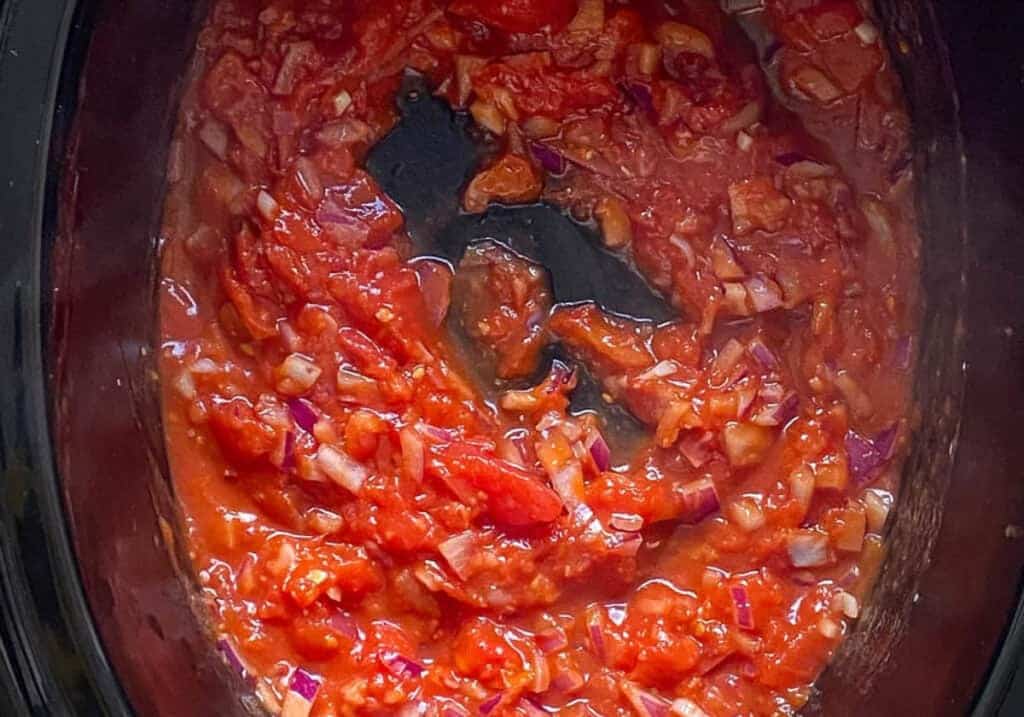 Tomatoes cooking in the Instant Pot with onions and spices.