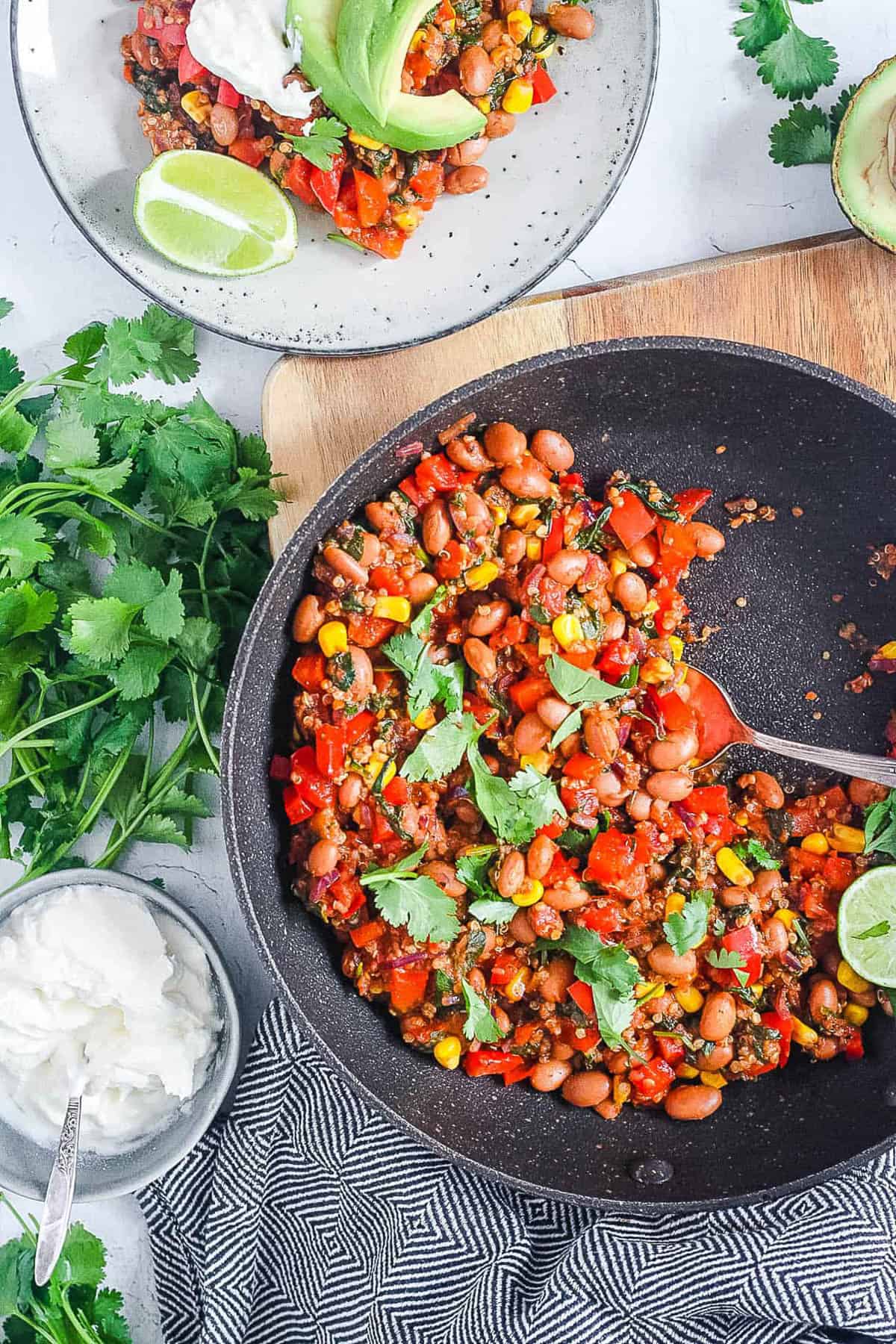 Overhead shot of a skillet and small white plate of pinto bean casserole.