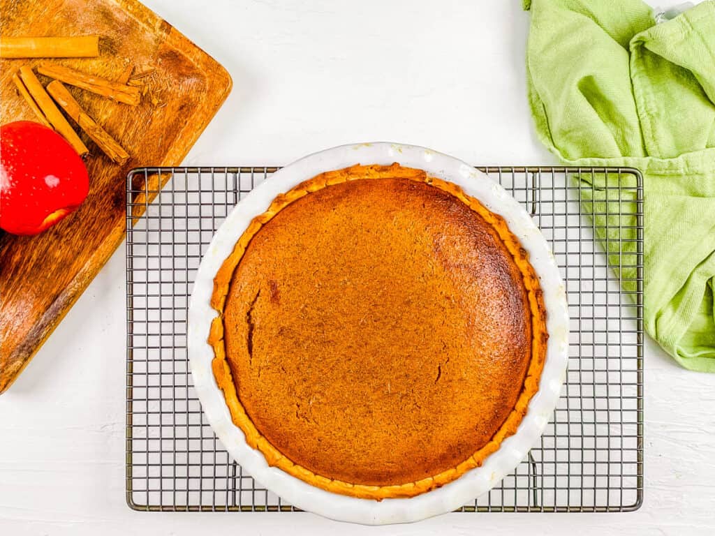 Baked pumpkin apple pie, fresh out of the oven, cooling on a wire rack.