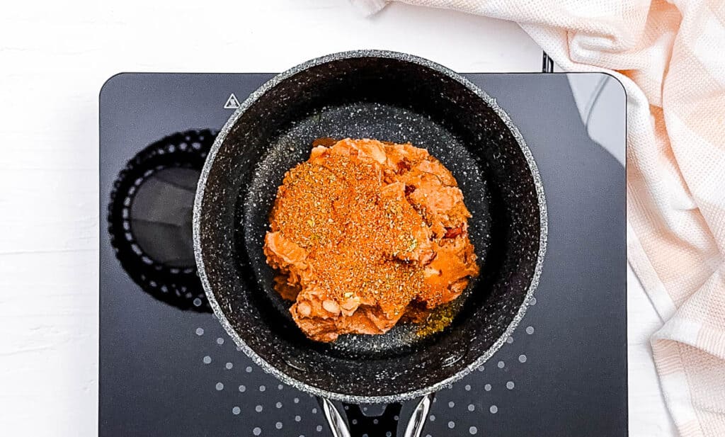 Refried beans cooking in a pot on the stove.