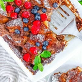 Overhead shot of a white pan of vegan french toast casserole with a serving spatula.