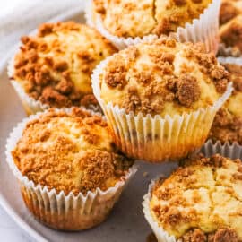 Cinnamon streusel muffins served on a white plate.