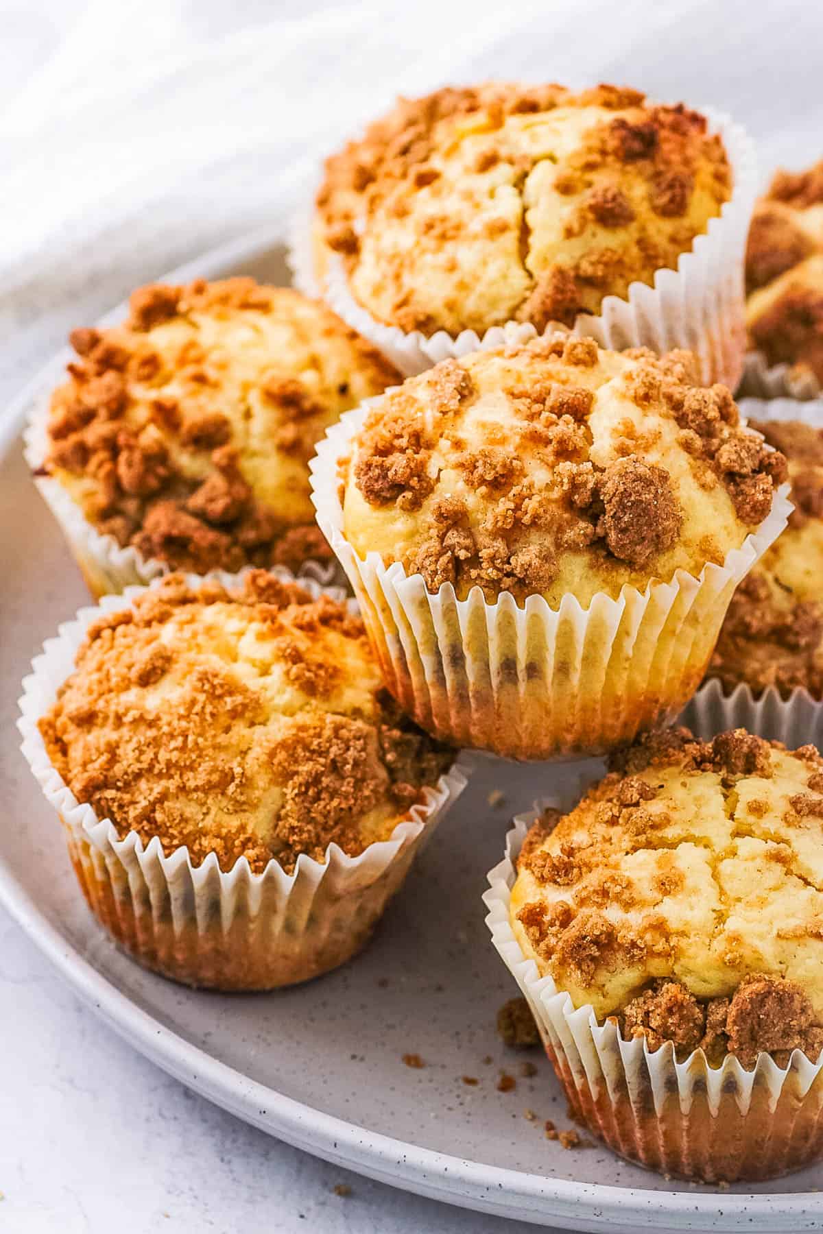 Cinnamon streusel muffins served on a white plate.