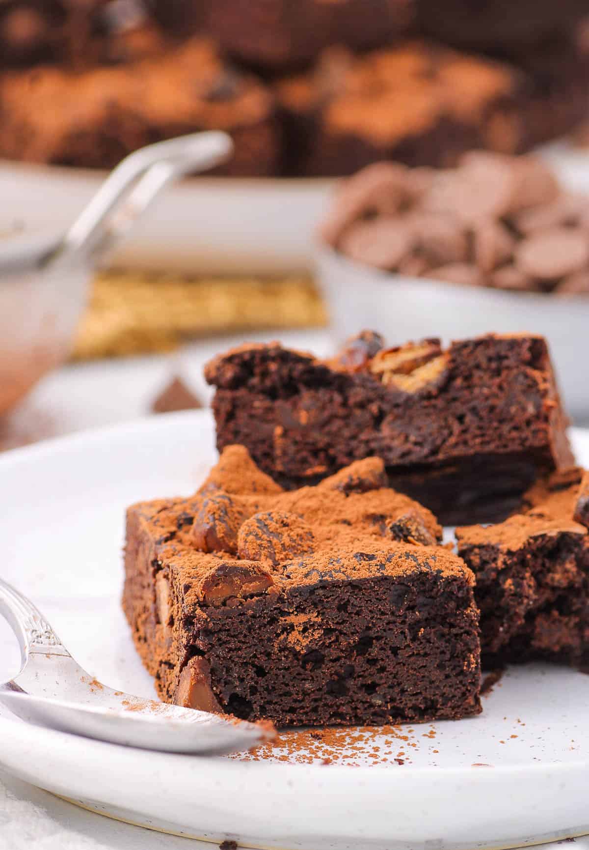 Flourless gluten free brownies stacked on a white plate.