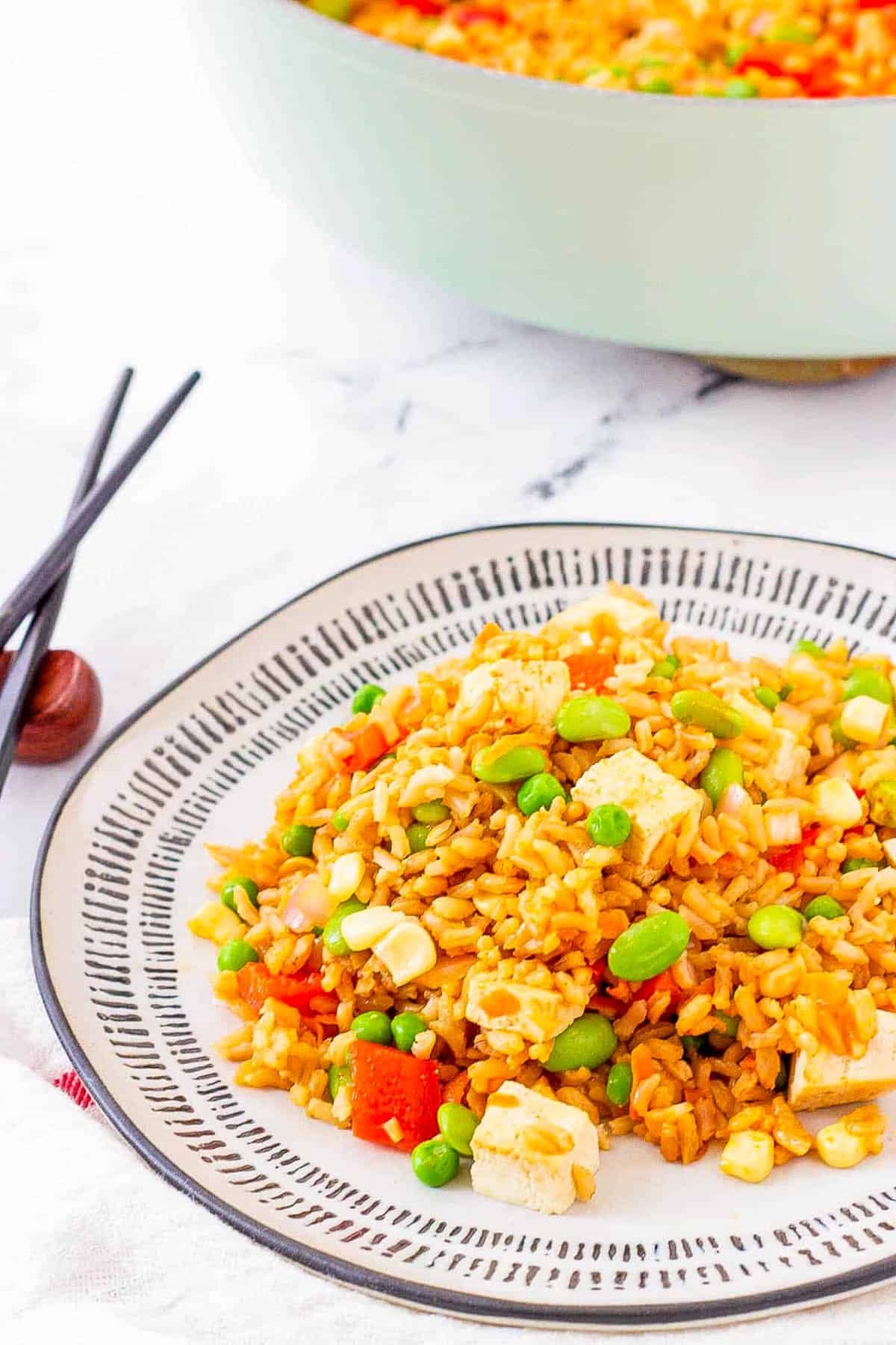 Easy tofu fried rice with vegetables, served on a white plate.
