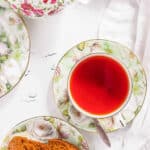 Black tea in a teacup on a tablecloth in this guide for how to make tea.