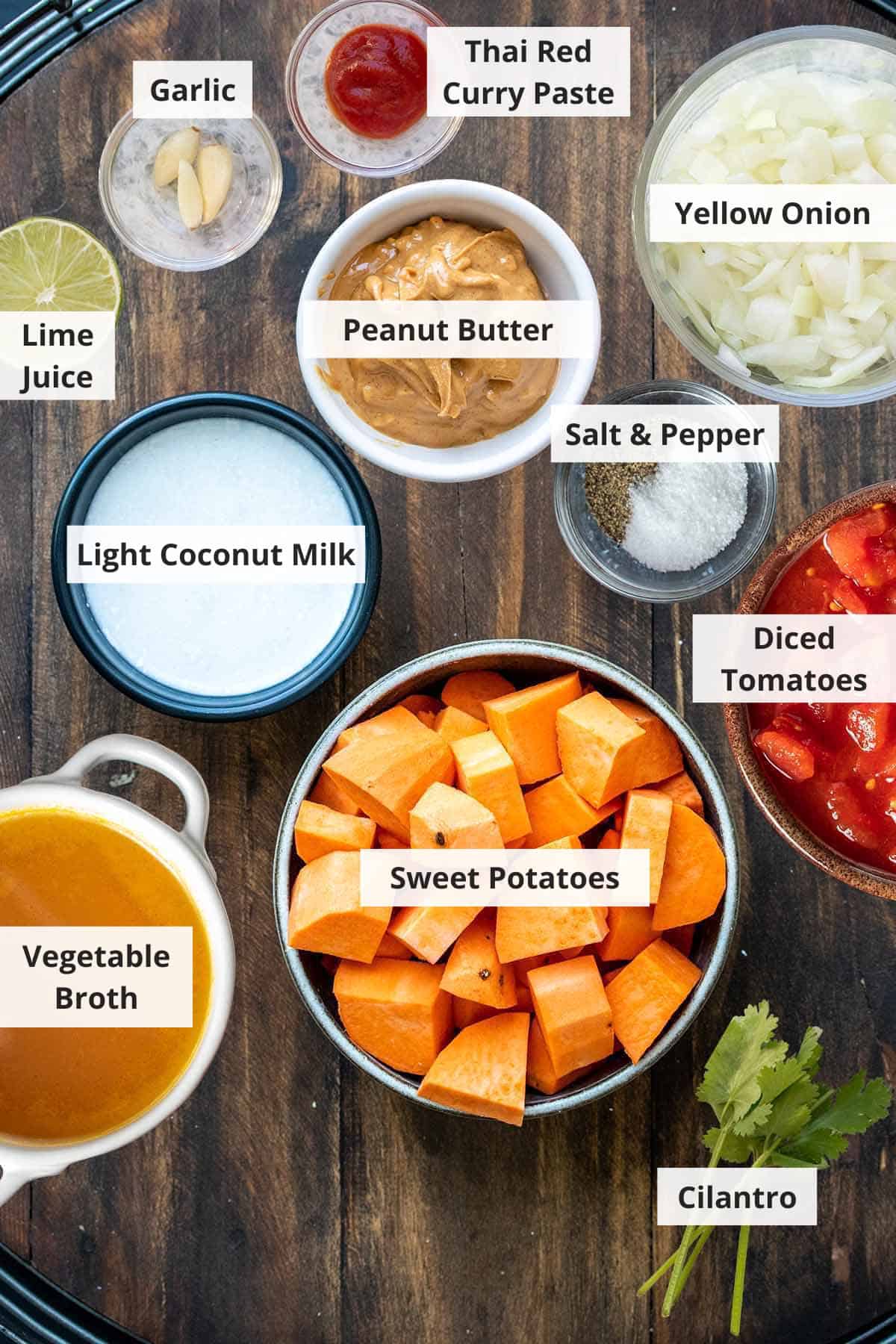 Ingredients for vegan sweet potato curry on a wood background.