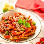 Vertical shot of Italian pasta penne plate with tomato sauce and cheese parmesan.